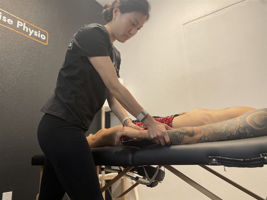Dr. Ko working hands-on on a client's arm during an assessment